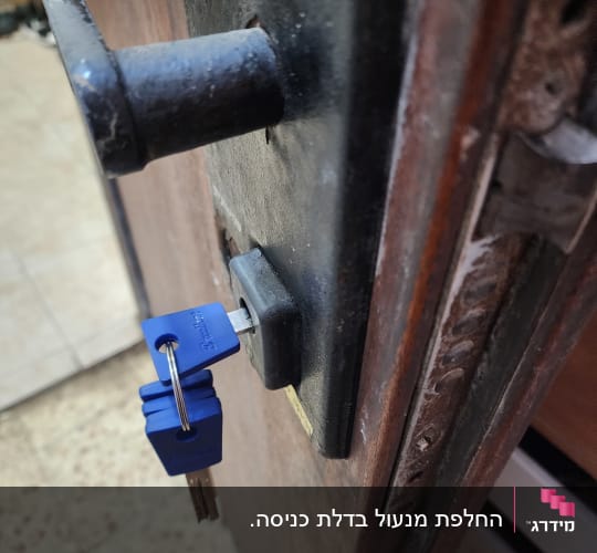 מנעול עם מפתח כחול בדלת עץ